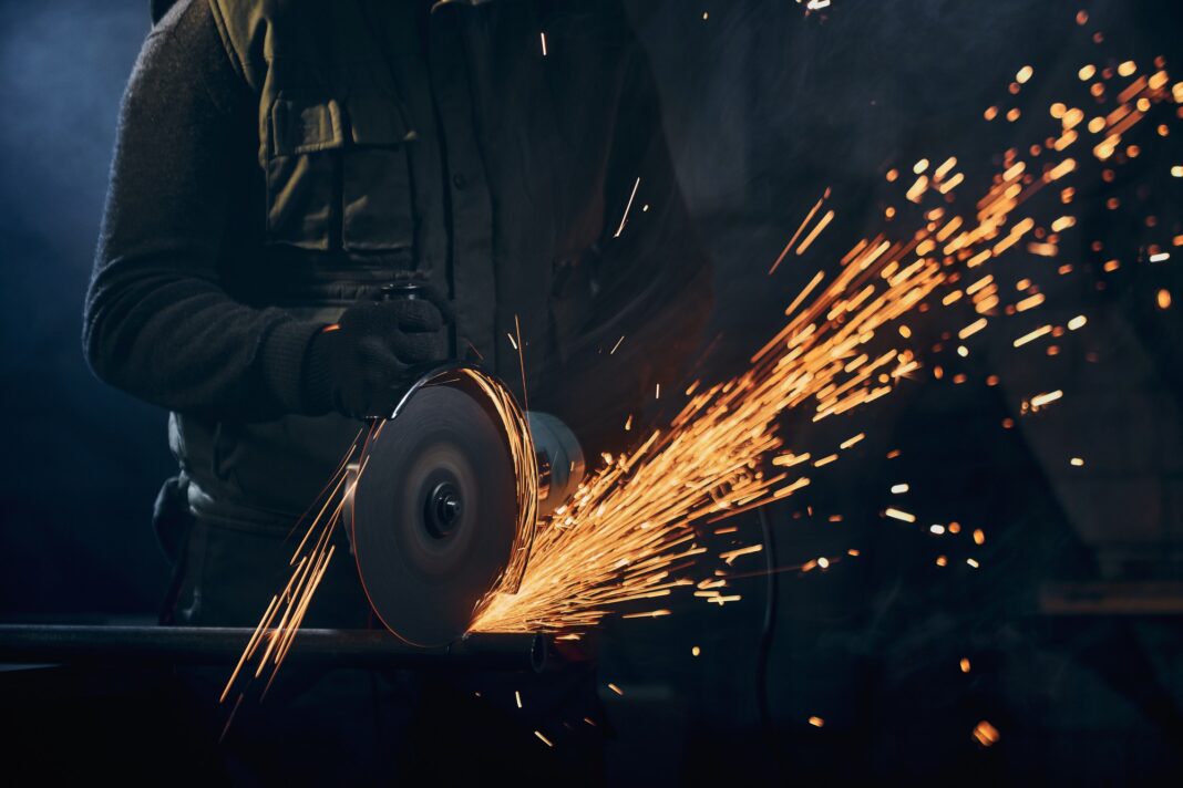 worker-protective-gloves-polishing-metal-with-sparks O plano, que está sendo discutido internamente, inclui possíveis restrições adicionais às importações de aço para garantir a viabilidade da indústria metalúrgica europeia
